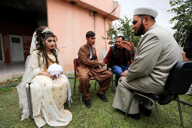 Iraqi newlyweds, who fled Mosul, Hussain Zeeno Zannun (C), 26, and Chahad, 16, listen to the imam while he conducts the religious marriage procedure outside a restaurant near Khazer camp, Iraq February 16, 2017. (Photo by Zohra Bensemra/Reuters)