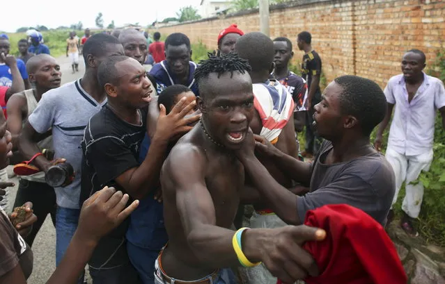 A mob attacks a female police officer accused of shooting a protester in Buterere neighborhood of Bujumbura, Burundi, May 12, 2015. (Photo by Goran Tomasevic/Reuters)