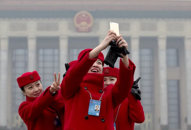 Chinese hostesses who serves the delegates of the Chinese People's Political Consultative Conference (CPPCC) take a photo of themselves during the opening session of the CPPCC at the Great Hall of the People in Beijing Monday, March 3, 2014. (Photo by Andy Wong/AP Photo)