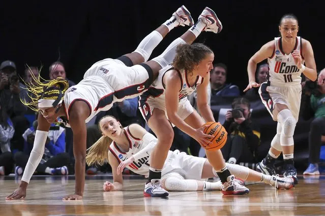 UConn forward Aaliyah Edwards, left, dives over UConn guard Ashlynn Shade during the first half of the team's Sweet 16 college basketball game against Duke in the women's NCAA Tournament, Saturday, March 30, 2024, in Portland, Ore. (Photo by Howard Lao/AP Photo)