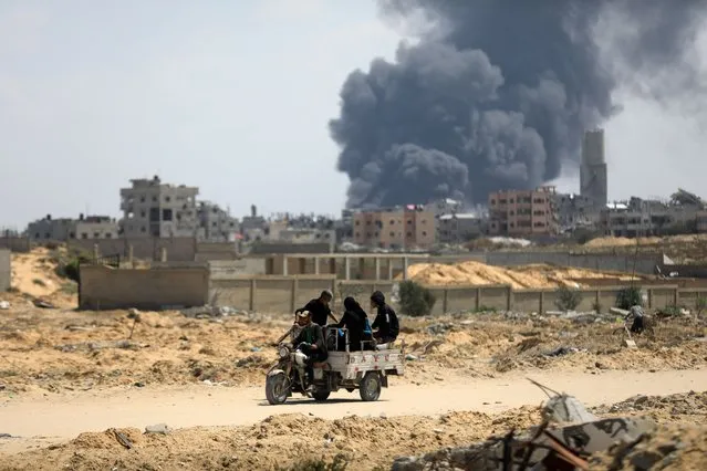 Black smoke rises among the streets of the city after Israeli attacks as some of the Palestinians return to their homes in Khan Yunis, Gaza on April 11, 2024. (Photo by Yasser Qudaih/Anadolu via Getty Images)