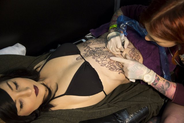 A woman is tattooed during the Great British Tattoo Show in Alexandra Palace in north London, Britain May 23, 2015. (Photo by Neil Hall/Reuters)