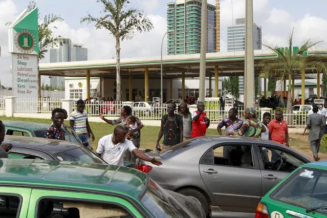 A woman holding her baby argues with a man outside the NNPC mega petrol station in Abuja, Nigeria May 25, 2015. (Photo by Afolabi Sotunde/Reuters)