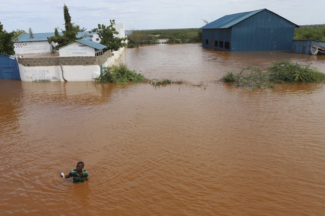 A man swims from a submerged church compound, after the River Tana broke its banks following heavy rains at Mororo, border of Tana River and Garissa counties, North Eastern Kenya, Sunday, April. 28, 2024. Heavy rains pounding different parts of Kenya have led to dozens of deaths and the displacement of tens of thousands of people, according to the U.N. (Photo by Andrew Kasuku/AP Photo)