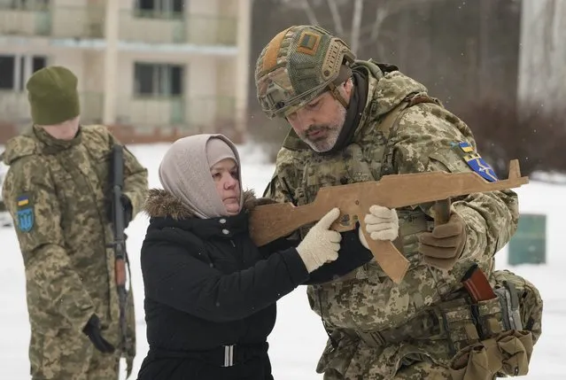 An instructor trains Rumia, 59, a member of Ukraine's Territorial Defense Forces, close to Kyiv, Ukraine, Saturday, February 5, 2022. Hundreds of civilians have been joining Ukraine's army reserves in recent weeks amid fears about a Russian invasion. (Photo by Efrem Lukatsky/AP Photo)
