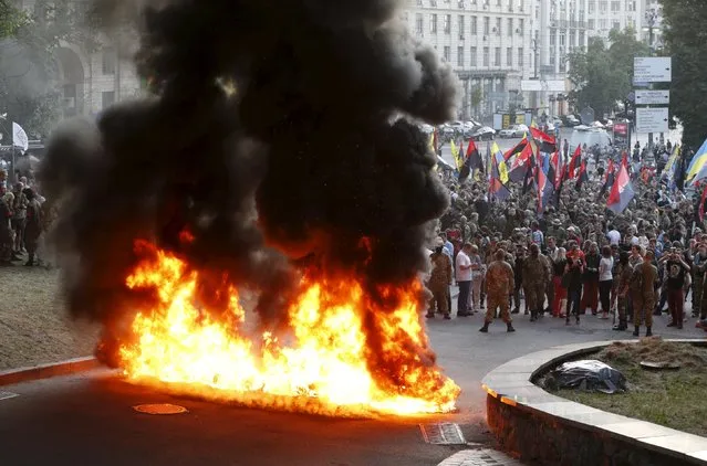 Tyres are set on fire during a rally held by members of the far-right radical group Right Sector, representatives of the Ukrainian volunteer corps and their supporters in central Kiev, Ukraine, July 3, 201. (Photo by Valentyn Ogirenko/Reuters)
