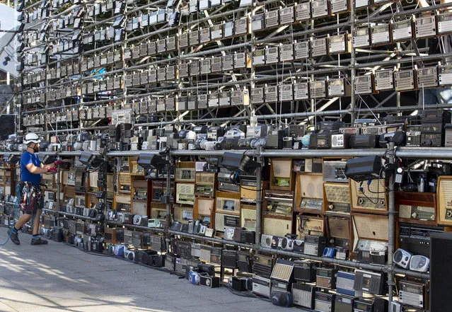 A technician prepares a giant construction made up of nearly 1,500 old radios on Vilnius Cathedral square, to commemorate events of 1989 when analog radios were used to coordinate so called Baltic Way human chain, in Vilnius, Lithuania, Friday, August 23, 2019. Estonia's prime minister says one should never forget the 1989 “Baltic Way” in which nearly 2 million people of then-Soviet Lithuania, Latvia and Estonia formed a human chain more than 600 kilometers (370 miles) long to protest Soviet occupation. (Photo by Mindaugas Kulbis/AP Photo)