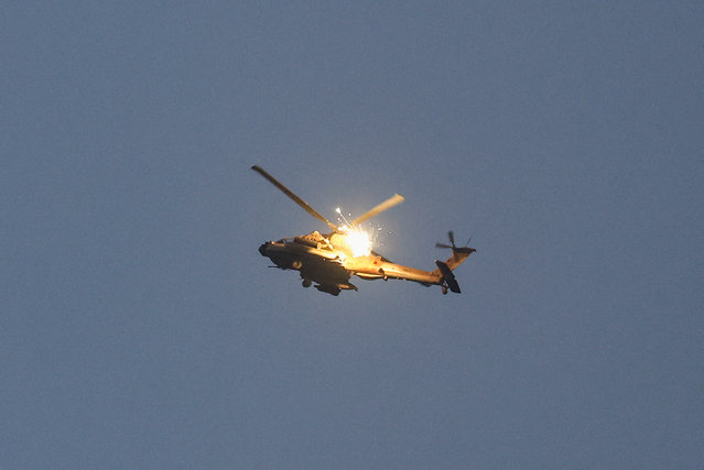An Apache helicopter releases flares as it flies near the border with Gaza amid the ongoing conflict between Israel and the Palestinian Islamist group Hamas, as seen from Israel on May 20, 2024. (Photo by Amir Cohen/Reuters)