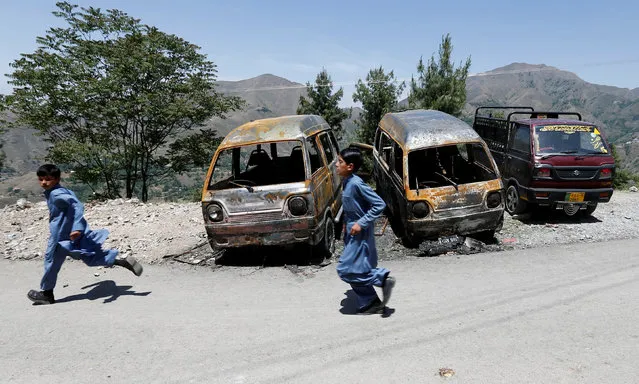 Children run past vans, one of which Ambreen was burned in, in the village of Makol outside Abbottabad, Pakistan May 6,  2016. (Photo by Caren Firouz/Reuters)