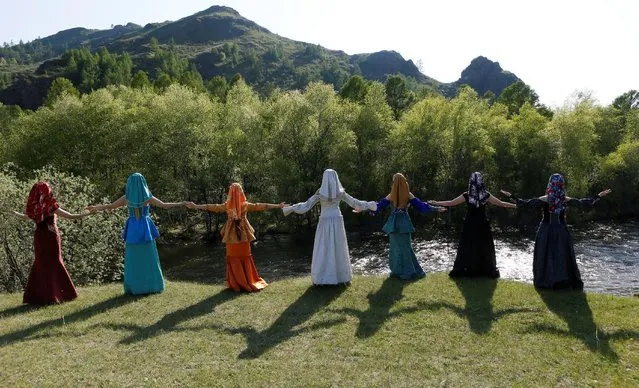 Models of the "Altyr" fashion theatre, dressed in Khakas national costumes, reconstruct the Seven Sisters national epos during a photo session, as a part of the rehearsal for the Tun-Pairam traditional holiday (The Holiday of the First Milk) celebration at a museum preserve outside Kazanovka village near Abakan in the Republic of Khakassia, Russia, May 28, 2016. The museum preserve is located in a picturesque forest-steppe valley near the Abakan ridge of the Kuznetsk Alatau mountain range and displays numerous objects of the cultural and historical heritage of various epochs accumulated by the people living on this territory, according to representatives. (Photo by Ilya Naymushin/Reuters)