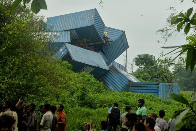 People gather near the carriages of a goods train after it collided with a passenger train in Nirmaljote, near Rangapani station in India's West Bengal state on June 17, 2024. At least eight people were killed in India on June 17 when a goods train driver missed a signal and slammed into an express passenger train from behind, police and railway officials said. (Photo by Diptendu Dutta/AFP Photo)