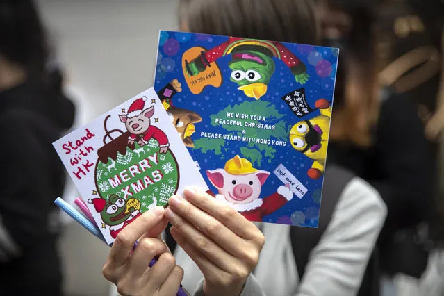 A protester holds Christmas cards for detained and jailed protesters during a rally in Hong Kong, Monday, December 16, 2019. China's premier said Monday that turmoil over amendments to extradition legislation has damaged Hong Kong society on all fronts. (Photo by Mark Schiefelbein/AP Photo)