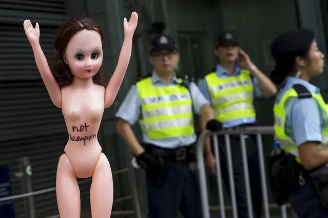 Protesters hold up a doll in front of police during a demonstration in support of Hong Kong female protester Ng Lai-ying, outside the police headquarters in Hong Kong, China August 2, 2015. Ng was sentenced to three and a half months in jail for using her breast to bump against police at an anti-parallel trading protest, local media reported. (Photo by Tyrone Siu/Reuters)