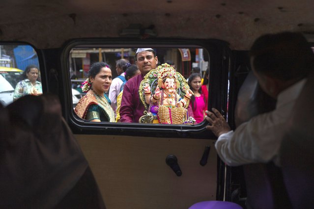 A family carries an idol of elephant-headed Hindu god Ganesha to home for worship during Ganesh Chaturthi festival celebrations in Mumbai, India, Saturday, September 7, 2024. (Photo by Rafiq Maqbool/AP Photo)