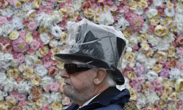 Britain Horse Racing, Royal Ascot, Ascot Racecourse on June 14, 2016. A racegoer with a plastic cover over his Tophat. (Photo by Toby Melville/Reuters/Livepic)