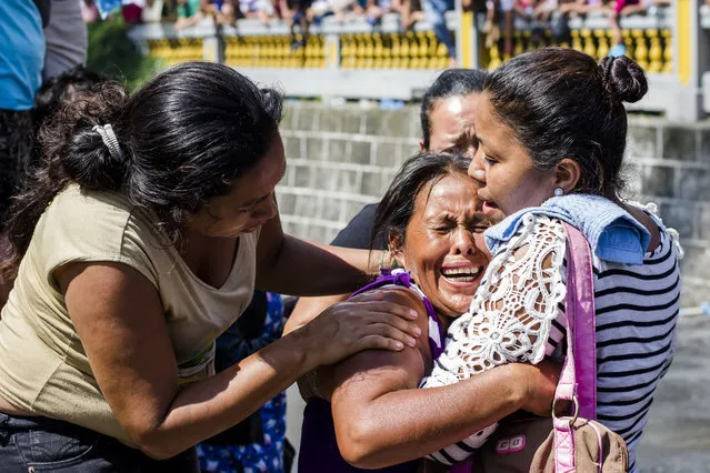 A relative of an inmate is comforted as more than a thousand inmates are bused out of the Cojutepeque prison in El Salvador, Thursday, June 16, 2016. (Photo by Salvador Melendez/AP Photo)