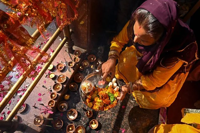 A Hindu devotee performs a religious ritual during the annual “Mela Kheer Bhawani” festival at a temple in Tullamulla village on the outskirts of Srinagar on June 8, 2022. (Photo by Tauseef Mustafa/AFP Photo)