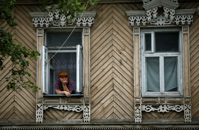 A woman looks out of window in Samara, Russia on July 18, 2017. (Photo by David Mdzinarishvili/Reuters)