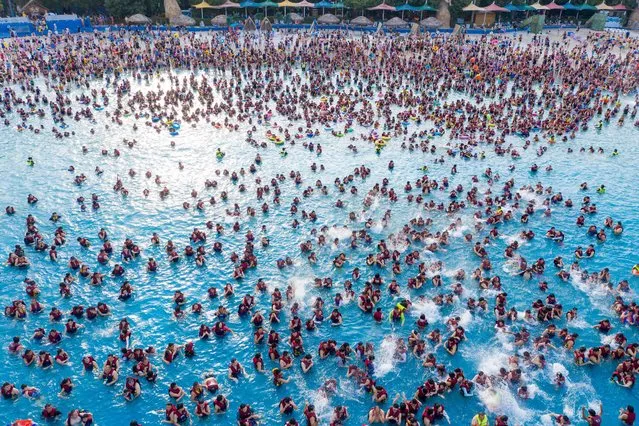 This aerial photo taken on June 25, 2022 shows people in a pool at a water park in Zhengzhou in China's central Henan province. (Photo by AFP Photo/China Stringer Network)