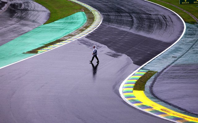 A man walks on the track as qualifying Formula One F1 is postponed due to bad weather at Autodromo Jose Carlos Pace in Sao Paulo, Brazil on November 2, 2024. (Photo by Amanda Perobelli/Reuters)