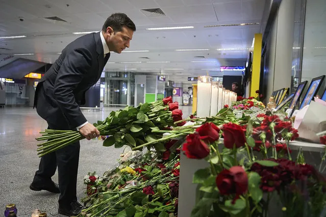 In this handout photo provided by the Ukrainian Presidential Press Office, Ukrainian President Volodymyr Zelenskiy lays flowers at a memorial of the flight crew members of the Ukrainian 737-800 plane that crashed on the outskirts of Tehran, at Borispil international airport outside in Kyiv, Ukraine, Thursday, January 9, 2020. A Ukrainian passenger jet carrying 176 people has crashed just minutes after taking off from the Iranian capital's main airport, turning farmland on the outskirts of Tehran into fields of flaming debris and killing all on board. (Photo by Ukrainian Presidential Press Office via AP Photo)