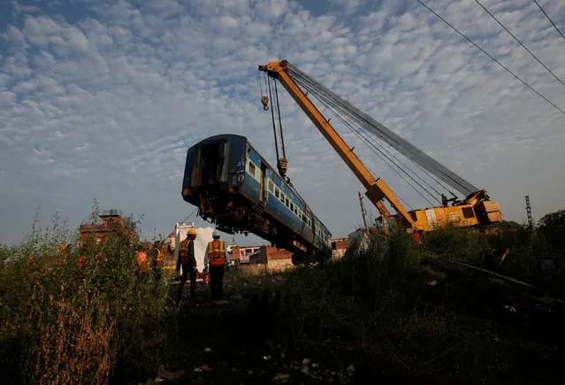 A damaged coach of a passenger train is removed from the site of an accident in Khatauli, in the northern state of Uttar Pradesh, India August 20, 2017. (Photo by Adnan Abidi/Reuters)