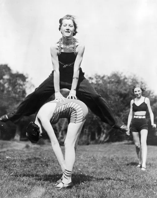 A group of women camping near the River Thames enjoy a game of leap-frog, 1935.