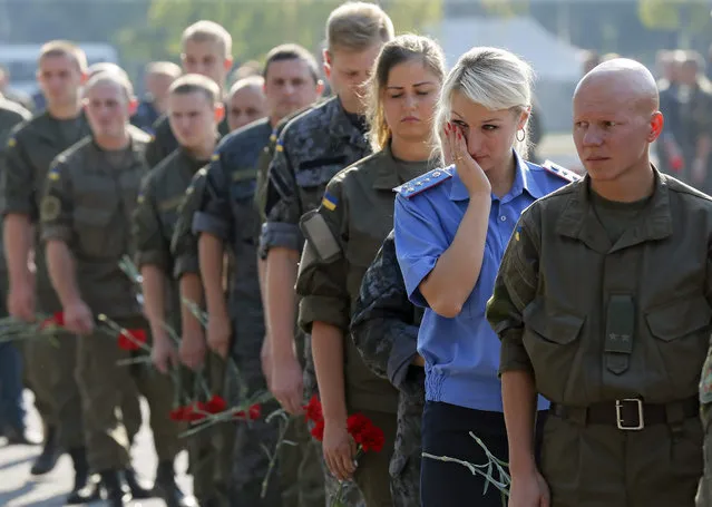 Ukrainian National Guard soldiers attend a funeral ceremony for Igor Debrin (24), who was killed at August 31 during clashes between protesters and police, at Novi Petrivtsi shooting range in Kiev, Ukraine, 02 September 2015. A Ukrainian policeman was killed and more 120 were injured in clashes with protesters outside the parliament in Kiev on 31 August after a vote to give more autonomy to the country's war-torn eastern regions. (Photo by Sergey Dolzhenko/EPA)