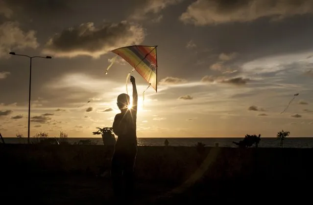 A child flies a kite in Cartagena, Colombia on August 24, 2014. (Photo by Joaquin Sarmiento/AFP Photo)