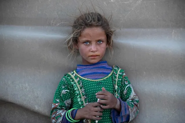 A girl stands at a camp for Syrians displaced by conflict near the Syrian northern city of Raqa on August 2, 2022. (Photo by Delil Souleiman/AFP Photo)