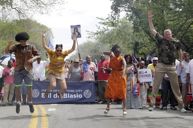 New York Mayor Bill de Blasio, right, and his children, Dante, left, and Chiara, second left, and wife, Chirlane McCray, do the “Smackdown” dance move as they march in the West Indian Day Parade, Monday, September 1, 2014, in the Brooklyn borough of New York. (Photo by Mark Lennihan/AP Photo)