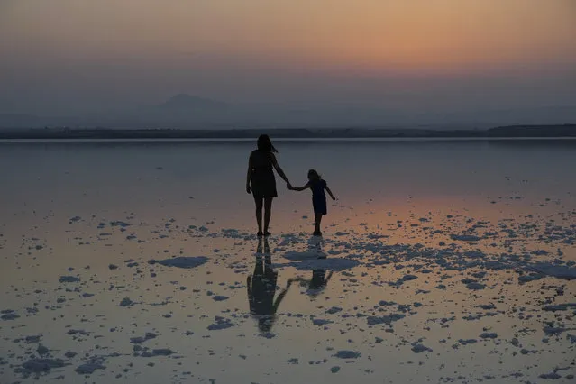 A mother with her daughter stand at the salt lake during sunset in southeast coastal city of Larnaca in southeast Mediterranean island of Cyprus, on Monday, September 5, 2022. (Photo by Petros Karadjias/AP Photo)