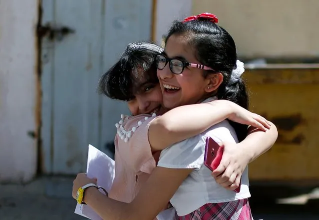 Palestinian students hug after receiving their certificates as preventive measures against the coronavirus disease (COVID-19) are taken, in al-Qahera school in Gaza City on May 21, 2020. (Photo by Mohammed Salem/Reuters)