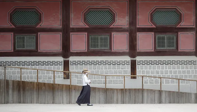 A woman wearing a face mask walks outside of Heungnyemun gate of the 14th-century Gyeongbok Palace, and one of South Korea's well-known landmarks, in Seoul, South Korea, Friday, June 19, 2020. (Photo by Lee Jin-man/AP Photo)