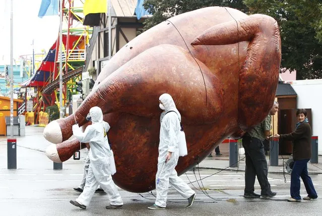 Environmental activists carry a giant inflatable chicken as the demonstrate against “chlorine chickens” near the Oktoberfest grounds in Munich October 1, 2014. The protest is against the planned Free Trade Agreements TTIP (Transatlantic Trade and Investment Partnership) and CETA (Comprehensive Economic and Trade Agreement) with the U.S. and Canada, which opponents fear will allow U.S. chlorine-washed chicken and hormone treated meat into the EU. (Photo by Michaela Rehle/Reuters)