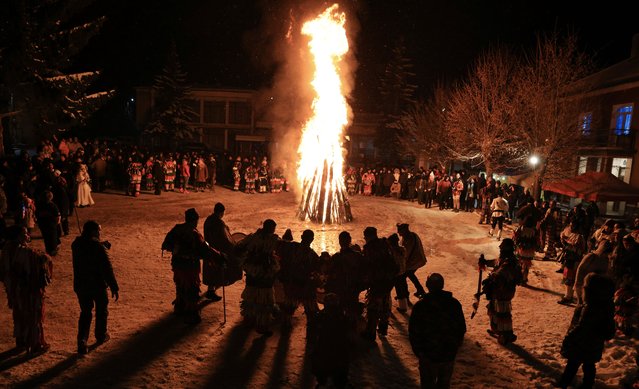 Costumed people, a so-called “Kuker” mask dancer, perform a traditional dance during carnival celebrations of Surva in the village of Elovdol, Bulgaria, 13 January 2025. In ancient times, the old Thracians held the Kukeri Ritual Games in honor of god Dionysus - known as a god of wine and ecstasy. Among the Kukeri (singular: kuker) dancers' are many characters, including Dionysus and his satyrs as well as others from deep history such as the tsar, harachari, plyuvkachi, startzi, and pesyatzi. (Photo by Vassil Donev/EPA/EFE)