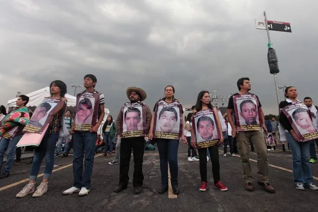 Mexicans citizens hold signs depicting several missing education students while attending a concert entitled “Voces por los 43” (lit. Voices for the 43) in commemoration of the 43 missing education students from the Ayotzinapa Rural Teacher's College, at the Azteca Stadium in Mexico City, Mexico, 26 August 2016. The 43 missing students, who were abducted after a clash with local police while travelling to Mexico City on 26 September 2016, were presumably kidnapped and murdered, although the culprits of the alleged crime have yet to be formally identified. The concert was held to mark the 23 months that have passed since the students were declared missing. (Photo by Sashenka Gutierrez/EPA)