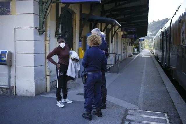 French police detain a woman who was travelling on a train crossing into France from Italy at the Menton Garavan train station in Menton, southern France, Sunday, November 13, 2022. Lines formed Sunday at one of Italy’s northern border crossings with France following Paris’ decision to reinforce border controls over a diplomatic row with Italy about migration policy and humanitarian rescue ships that shows no end in sight. (Photo by Daniel Cole/AP Photo)