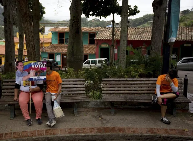 In this Thursday, December 7, 2017 photo, supporters of opposition mayoral candidate Yon Goicoechea wait for the start of a campaign rally, in Caracas, Venezuela. Still bruising from a shock defeat in recent gubernatorial races, the opposition is limping into Sunday’s vote deeply divided, with three of the four biggest parties in the Democratic Unity coalition boycotting the race altogether. (Photo by Fernando Llano/AP Photo)