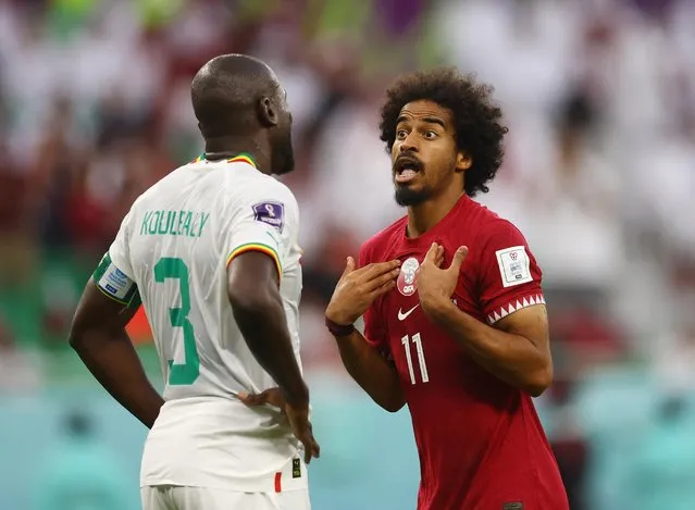 Senegal's defender #03 Kalidou Koulibaly (L) and Qatar's forward #11 Akram Afif (R) clash during the Qatar 2022 World Cup Group A football match between Qatar and Senegal at the Al-Thumama Stadium in Doha on November 25, 2022. (Photo by Kai Pfaffenbach/Reuters)