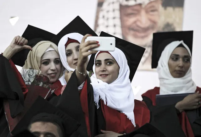 Palestinians students pose for a selfie during the graduation ceremony at the Palestine Technical College at West Bank refugee camp of Al-Aroub, near Hebron, 26 August 2015. (Photo by Abed Al Hashlamoni/EPA)