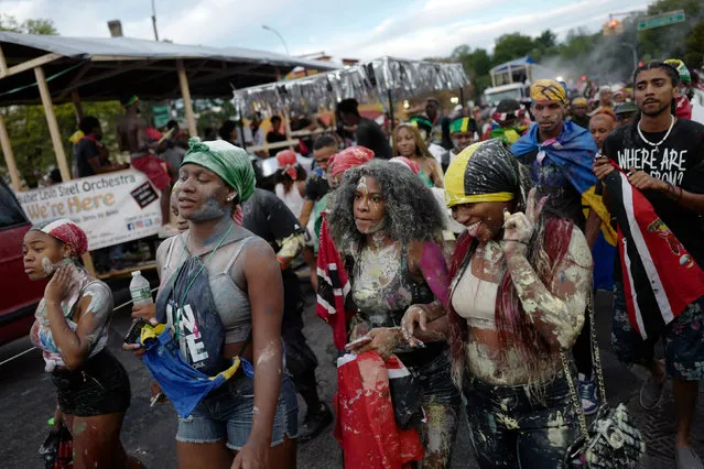 A woman gestures at friends while marching in J'Ouvert, ahead of the annual West Indian-American Carnival Day Parade in Brooklyn, NY, U.S. September 5, 2016. (Photo by Mark Kauzlarich/Reuters)