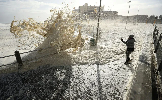 People watch spray thrown up by huge swells as a cold front moves in over Cape Town, South Africa, July 13, 2020. (Photo by Mike Hutchings/Reuters)