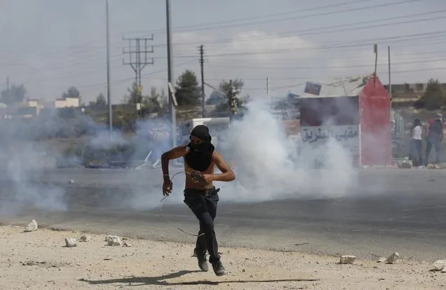 A Palestinian protester runs during clashes with Israeli troops near the Jewish settlement of Bet El, near the occupied West Bank city of Ramallah October 5, 2015. (Photo by Mohamad Torokman/Reuters)