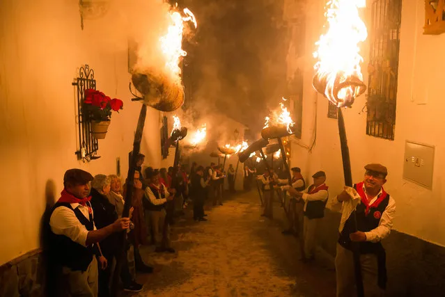 Villagers are seen holding torches on the street as they take part in the celebration of the “Divina Pastora” Virgin procession. On the eve of the feast of St. Lucia in the small village of Casarabonela, every night of 12 December during the Christmas season villagers take part in the ancient celebration of “Los Rondeles” carrying burning wickers baskets (also known as “rondeles”) soaked in oil. Along the streets, the Virgin of “Los Rondeles” is honored by the devotees in a ritual of light and fire as thanksgiving for the harvest obtained. (Photo by Jesus Merida/SOPA Images/Rex Features/Shutterstock)