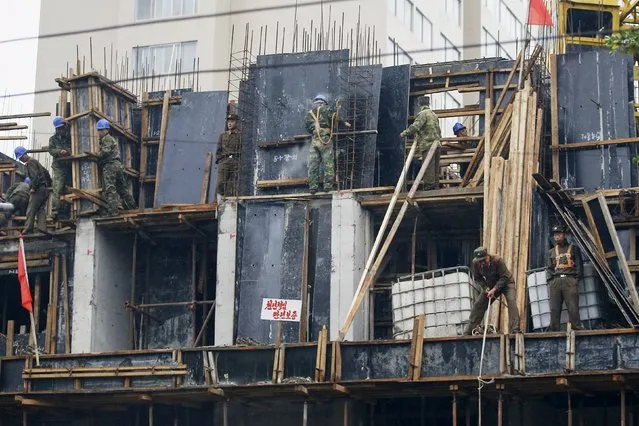 "Soldier-builders" work on a construction site in central Pyongyang, October 11, 2015. (Photo by Damir Sagolj/Reuters)