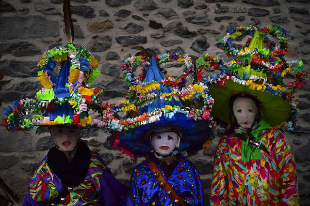A group of participants dressed in traditional clothes and wearing large hats decorated with ribbons and feathers, known as '“Ttutturo”', take part in the Carnival of the Pyrenees villages of Leitza, northern Spain, Tuesday, January 30, 2018. (Photo by Alvaro Barrientos/AP Photo)