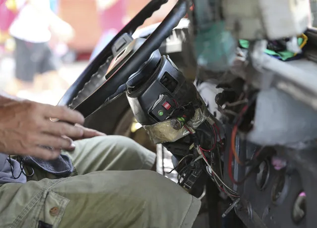 In this September 19, 2017, photo, a Filipino driver sits at the wheel of his jeepney with exposed ignition wiring as he prepares for his trip in Manila, Philippines. The iconic passenger jeepney is chugging toward change and uncertainty as a government modernization program aims to improve their engines, safety and convenience in an overhaul that poor Filipino drivers and owners say they can't afford. (Photo by Aaron Favila/AP Photo)