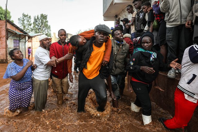 Locals carry an unconscious woman (C) who nearly drowned after being trapped in her flooded home following a night of heavy rainfall and the overflowing of Gitathuru river that broke its banks damaging surrounding neighborhoods, in the Ngondo village, in Mathare, Nairobi, Kenya, 24 April 2024. Kenya's meteorological department predicts more heavy rainfall this week, as floods continue to destroy properties in various parts of the country. According to the Kenya Red Cross Society, at least 103,485 people have been affected by the March-May long rains that continue to rise, including 40,265 people displaced, as of 18 April 2024. (Photo by Daniel Irungu/EPA/EFE/Rex Features/Shutterstock)