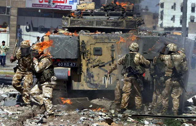 British soldiers come under attack in the southern Iraqi town of Basra, on Monday March 22 2004, during a protest by unemployed Iraqi civilians who failed to get jobs with the local customs office, and also condemned the assassination of Hamas founder Ahmed Yassin in Gaza City earlier in the day. (Photo by Nabil al-Jurani/AP Photo/The Atlantic)